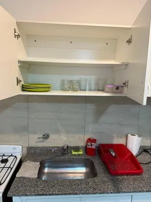 a kitchen counter top with a sink and a stove at house with garage in Cordoba