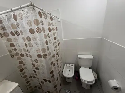 a bathroom with a toilet and a shower curtain at house with garage in Cordoba