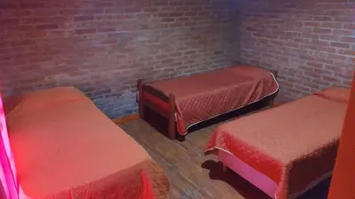 a room with two beds and a brick wall at canchu 11 in Arroyo de Los Patos