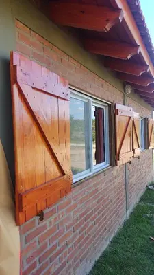 a brick house with a large wooden door and windows at canchu 11 in Arroyo de Los Patos