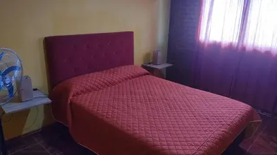 a bedroom with a red bed with a red comforter at canchu 11 in Arroyo de Los Patos