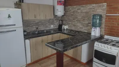 a kitchen with a white refrigerator and a stove at canchu 11 in Arroyo de Los Patos