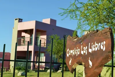 a sign on a fence in front of a building at Complejo Las Liebres in San Lorenzo