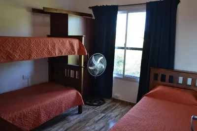 a bedroom with two bunk beds and a fan at Complejo Las Liebres in San Lorenzo