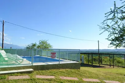 a house with a swimming pool and a fence at Complejo Las Liebres in San Lorenzo