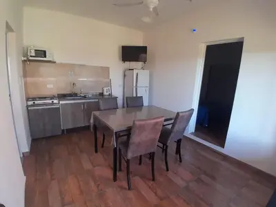 a kitchen with a table and chairs in a room at Complejo Las Liebres in San Lorenzo
