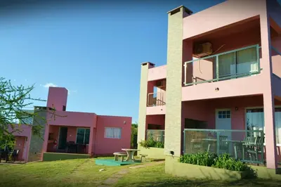 a pink building with a picnic table in front of it at Complejo Las Liebres in San Lorenzo