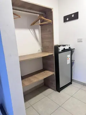 a kitchen with wooden shelves and a refrigerator at Posada La Pedrera in Villa Yacanto