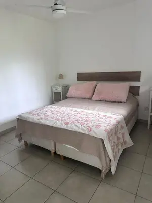 a bedroom with a large bed with pink pillows at Posada La Pedrera in Villa Yacanto