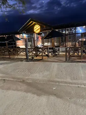 a group of tables and umbrellas in front of a restaurant at Posada La Pedrera in Villa Yacanto