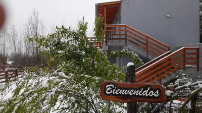 a sign in front of a building with snow on the ground at Posada La Pedrera in Villa Yacanto