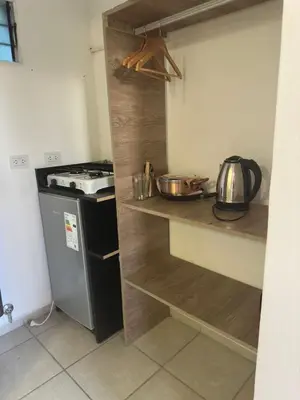 a kitchen with a counter with a stove and a refrigerator at Posada La Pedrera in Villa Yacanto
