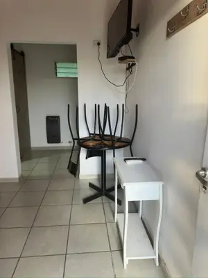 a room with a table and a chair and a television at Posada La Pedrera in Villa Yacanto