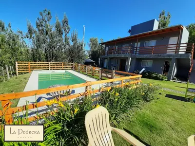 a house with a tennis court in the yard at Posada La Pedrera in Villa Yacanto
