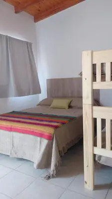 a bedroom with a bunk bed and a ladder at Posada La Pedrera in Villa Yacanto