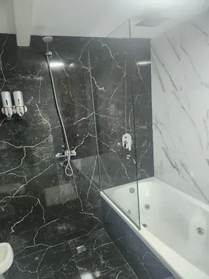 a black and white bathroom with a shower and a tub at Hotel El Paraiso Boutique in Villa Carlos Paz