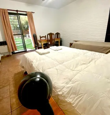a bedroom with a white bed and a chair at La cantata in Merlo