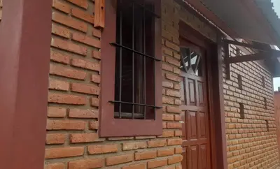 a brick wall with a window and a door at Las Lomitas in Villa Cura Brochero