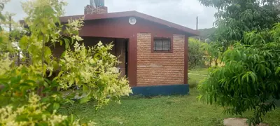 a small brick house in the middle of a yard at Las Lomitas in Villa Cura Brochero