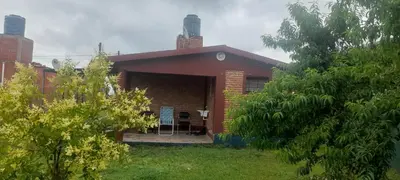 a small red brick house with a yard at Las Lomitas in Villa Cura Brochero