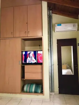 a room with a television in a room with a bed at Alquiler Temporario a una cuadra del reloj cucu in Villa Carlos Paz