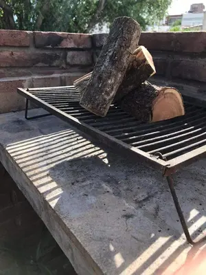 a tree on a grill with a log on it at Alquiler Temporario a una cuadra del reloj cucu in Villa Carlos Paz