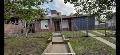 a bench in front of a house with a fence at Casa para 9 personas en Villa Carlos Paz in Villa Carlos Paz