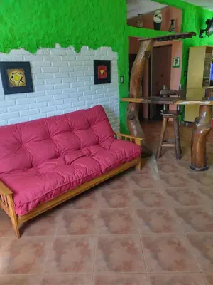 a pink couch in a room with green walls at Tiempo Libre in Villa Icho Cruz