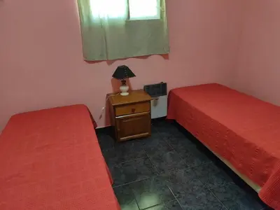 a room with two beds and a table with a lamp at Tiempo Libre in Villa Icho Cruz
