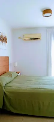 a bedroom with a green bed and a window at Nórdico Nueva Córdoba in Cordoba
