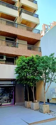 two trees sitting in front of a building at Nórdico Nueva Córdoba in Cordoba