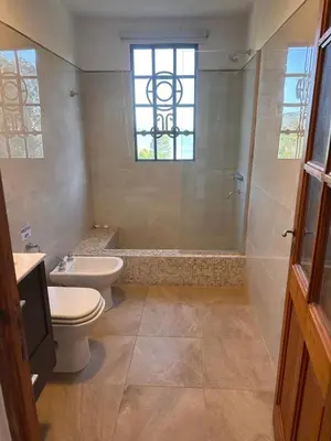 a bathroom with a toilet and a shower and a window at Punta Molinos in La Estancia