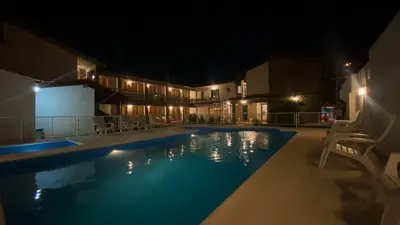 a swimming pool at night with chairs around it at Hosteria Torol Calta in Villa Cura Brochero