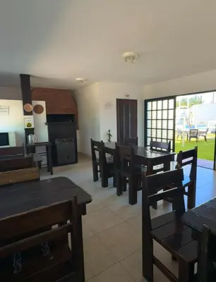 a dining room with wooden tables and chairs at Hosteria Torol Calta in Villa Cura Brochero