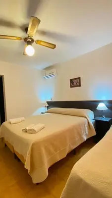 a bedroom with two beds and a ceiling fan at Hosteria Torol Calta in Villa Cura Brochero