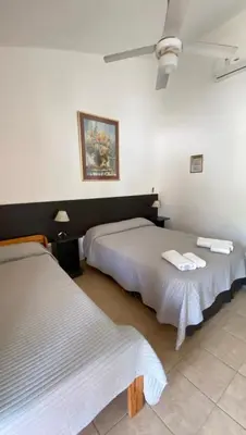 a bedroom with two beds and a ceiling fan at Hosteria Torol Calta in Villa Cura Brochero