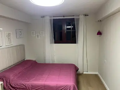 a bedroom with a pink bed and a window at Departamento Vivaldi in Villa Carlos Paz