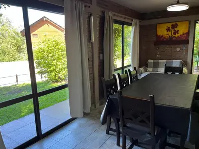 a dining room with a table and chairs and a window at Departamento Vivaldi in Villa Carlos Paz