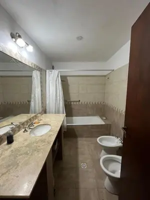 a bathroom with two sinks and a tub and two toilets at Departamento Vivaldi in Villa Carlos Paz