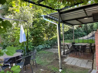 a patio with tables and chairs and an umbrella at Departamento Vivaldi in Villa Carlos Paz