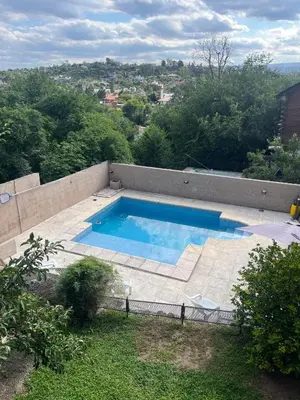a swimming pool on the side of a house at Departamento Vivaldi in Villa Carlos Paz