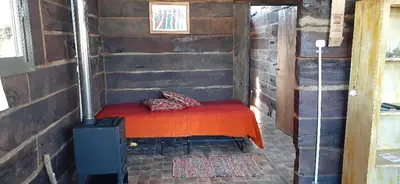 a small room with a red bed in a cabin at Naturaleza Serrana in La Estancia
