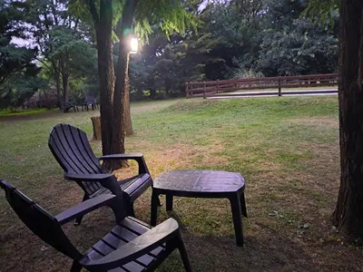 two chairs and a table in a park at Cabaña La Linda in Villa General Belgrano