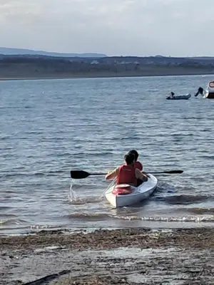 a woman and a child in a kayak in the water at Cabaña La Linda in Villa General Belgrano
