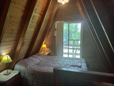 a bedroom with a large bed and a window at Cabaña La Linda in Villa General Belgrano