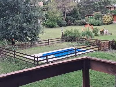 a wooden fence with a mattress on the grass at Cabaña La Linda in Villa General Belgrano