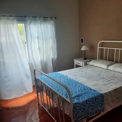 a bedroom with a bed and a window with curtains at La Jose in Santa María
