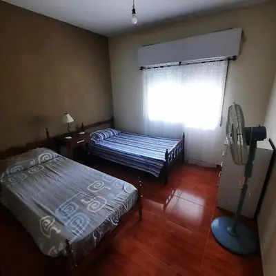 a room with two beds and a window with a fan at La Jose in Santa María