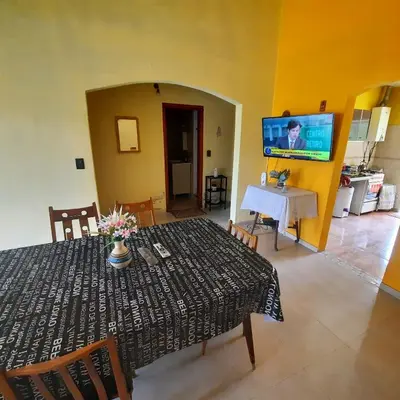 a dining room with a table and a tv on a wall at La Jose in Santa María