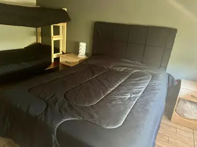 a large bed in a bedroom with a large bedspread at Adonay VGB in Villa General Belgrano
